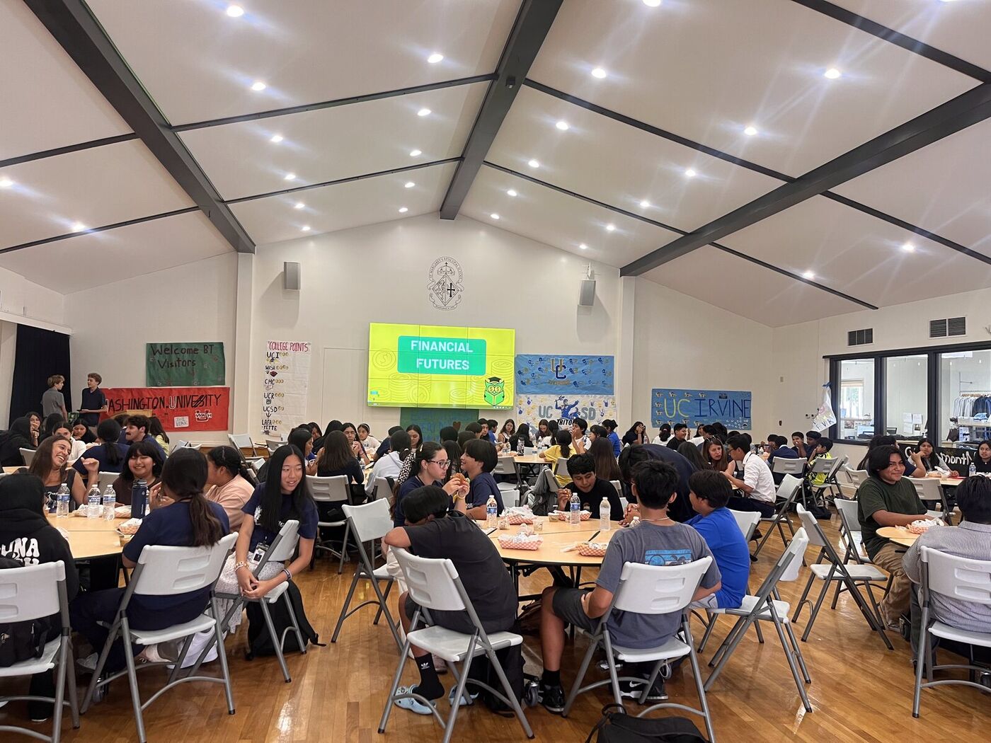 A hall full of students at round tables during a Financial Futures session