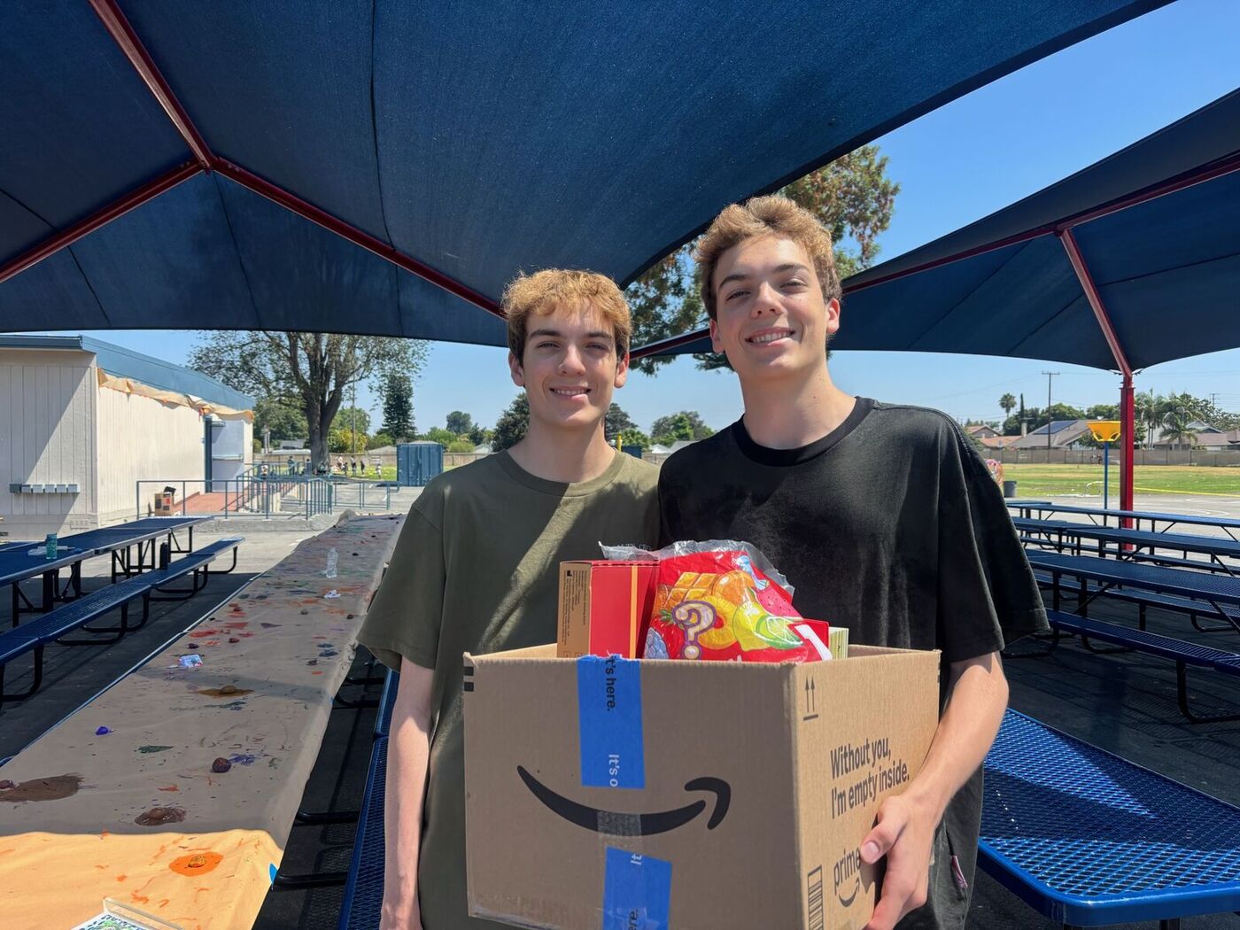Luke and Nick carrying a box of donated supplies