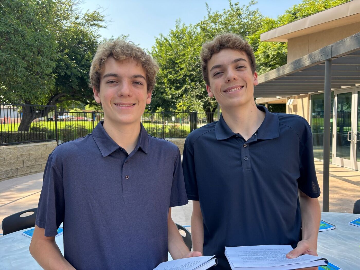 Luke and Nick Meggers smiling outdoors at camp
