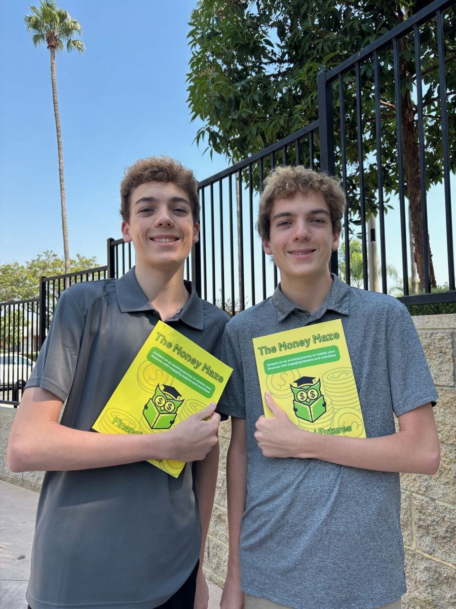 Luke and Nick holding copies of The Money Maze